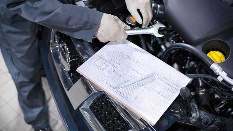 Car engine being repaired by mechanic for vehicle safety recall.